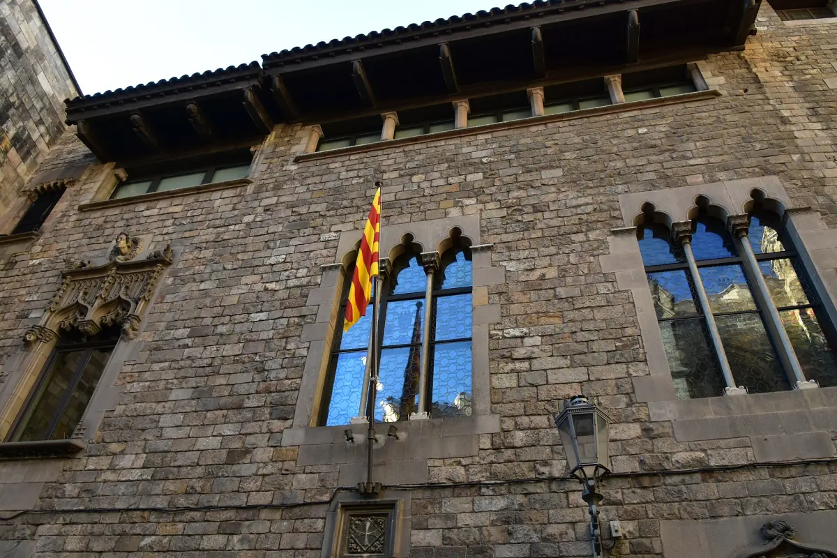 A medieval stone building with the Catalan flag in the Gothic Quarter