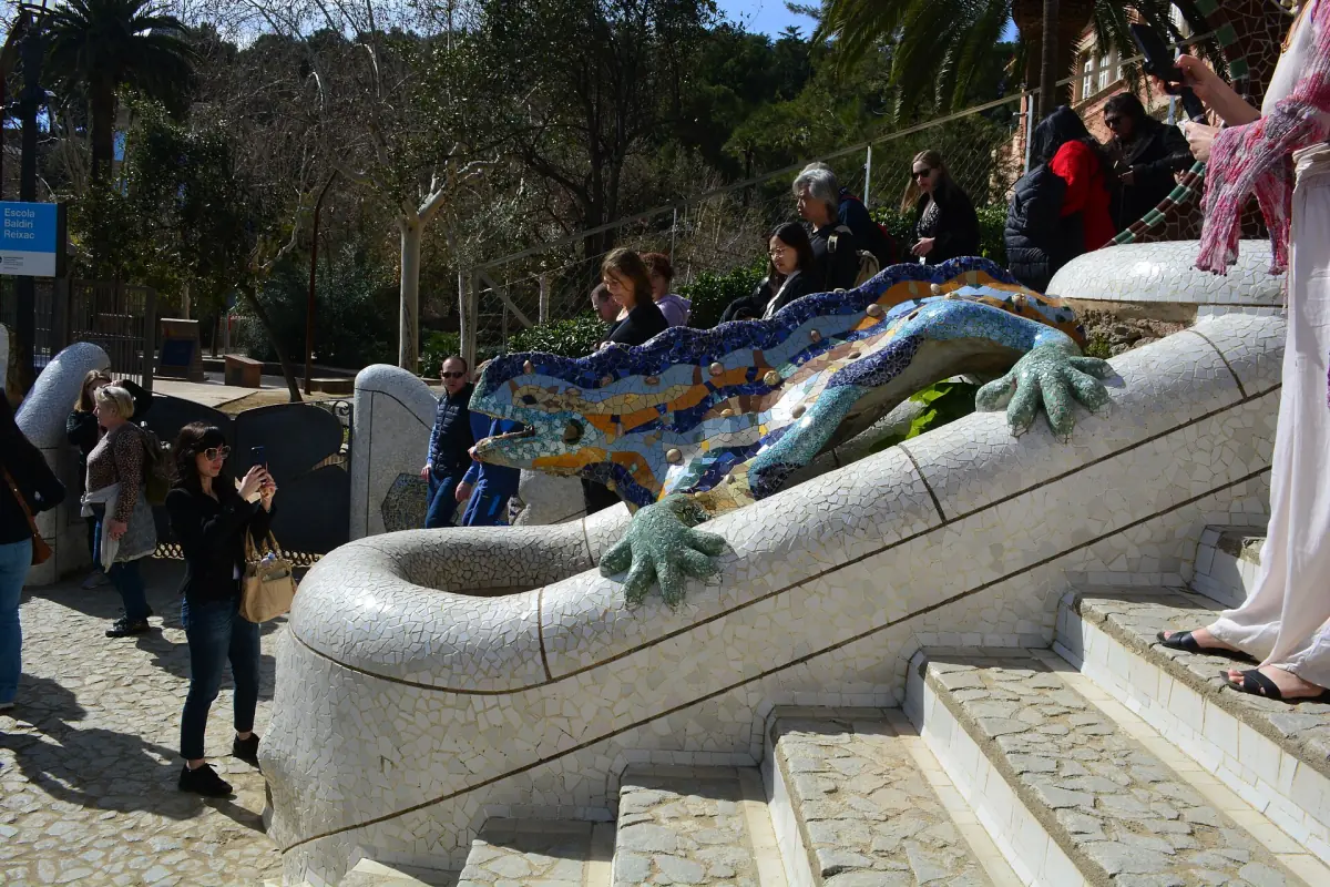 Visitors at the mosaic dragon on the main steps of Park Güell
