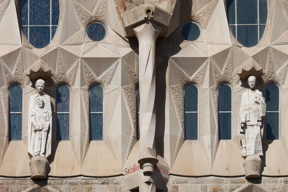 Angular stone figures and windows on an outer wall of the Sagrada Família