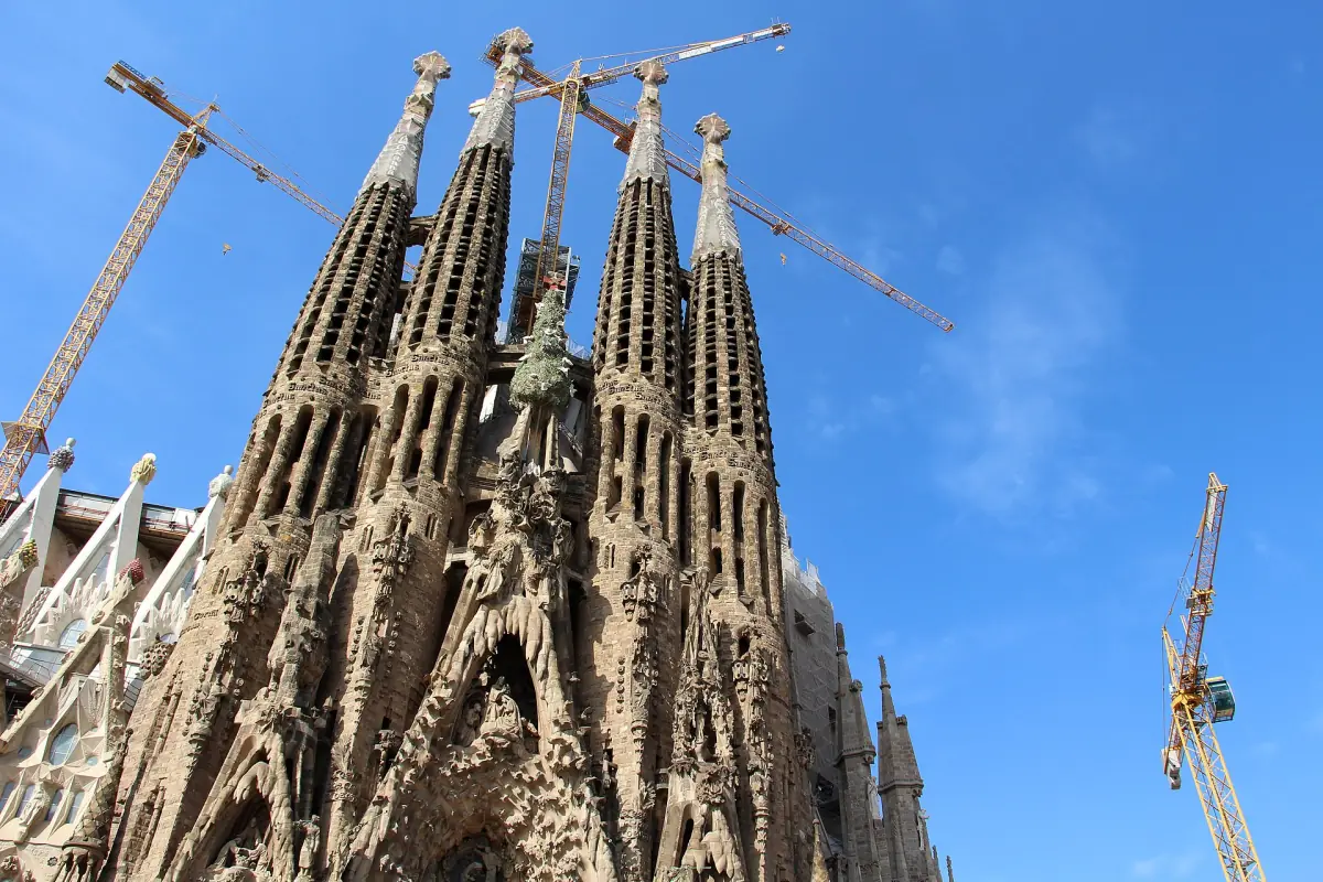 The towers of the Nativity facade of the Sagrada Família against a blue sky